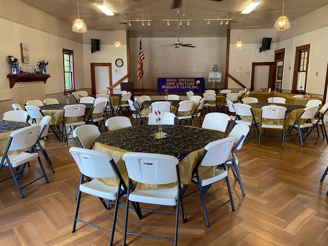 Clubhouse meeting room arranged with round tables and chairs